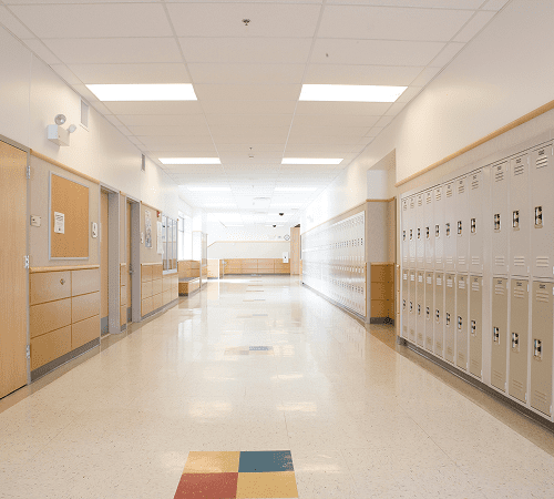 Empty school hallway with lockers and doors.