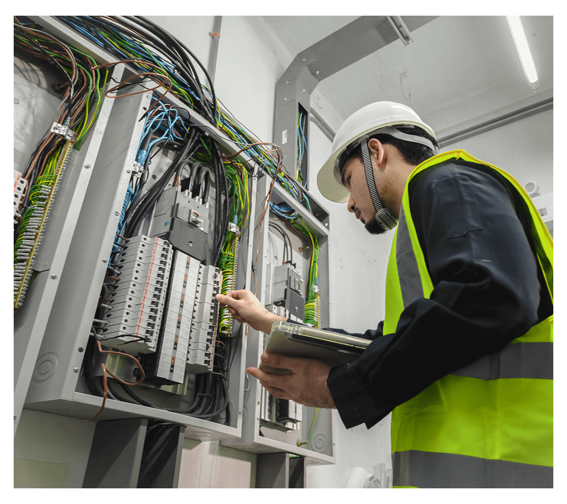 Electrician inspecting electrical panel with clipboard.